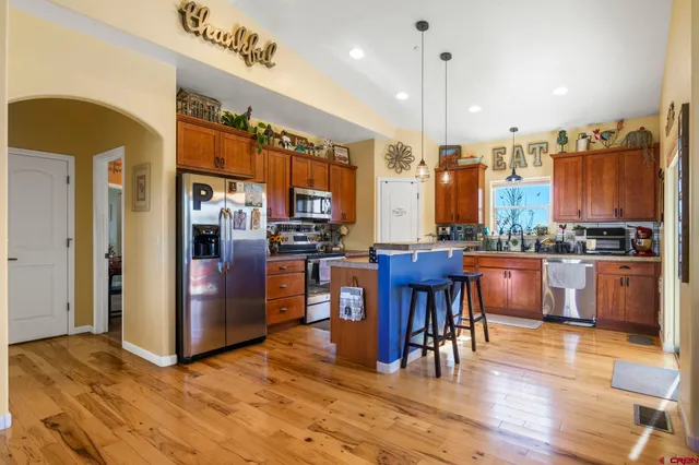 a view of kitchen with stainless steel appliances granite countertop a refrigerator and a stove top oven