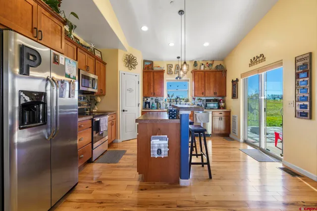 a living room with stainless steel appliances kitchen island granite countertop furniture a fireplace and a kitchen view