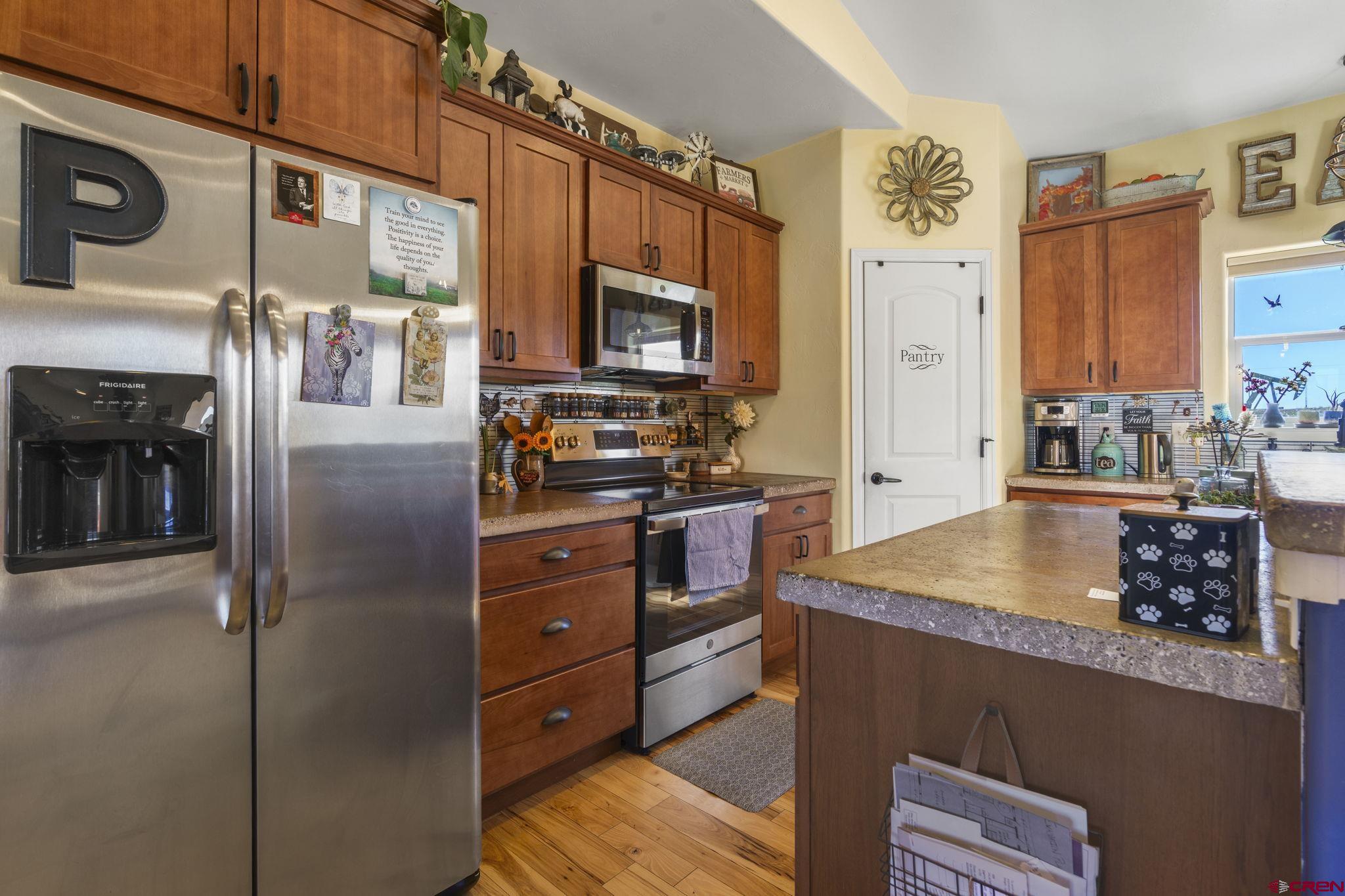 172 Encantado Lane Durango, CO 81303 - Photo 13 of 38 a kitchen with stainless steel appliances granite countertop a refrigerator and a stove top oven