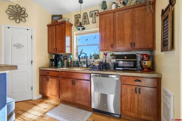 a kitchen with stainless steel appliances granite countertop a refrigerator a sink and wooden cabinets