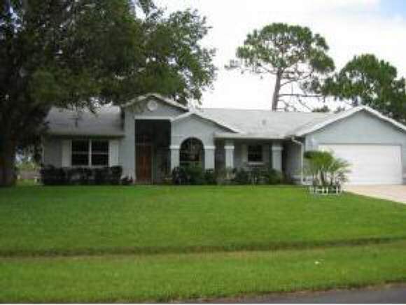 1205 Northwest Rugen Palm Bay, FL 32907 - Photo 1 of 5 a front view of a house with a garden