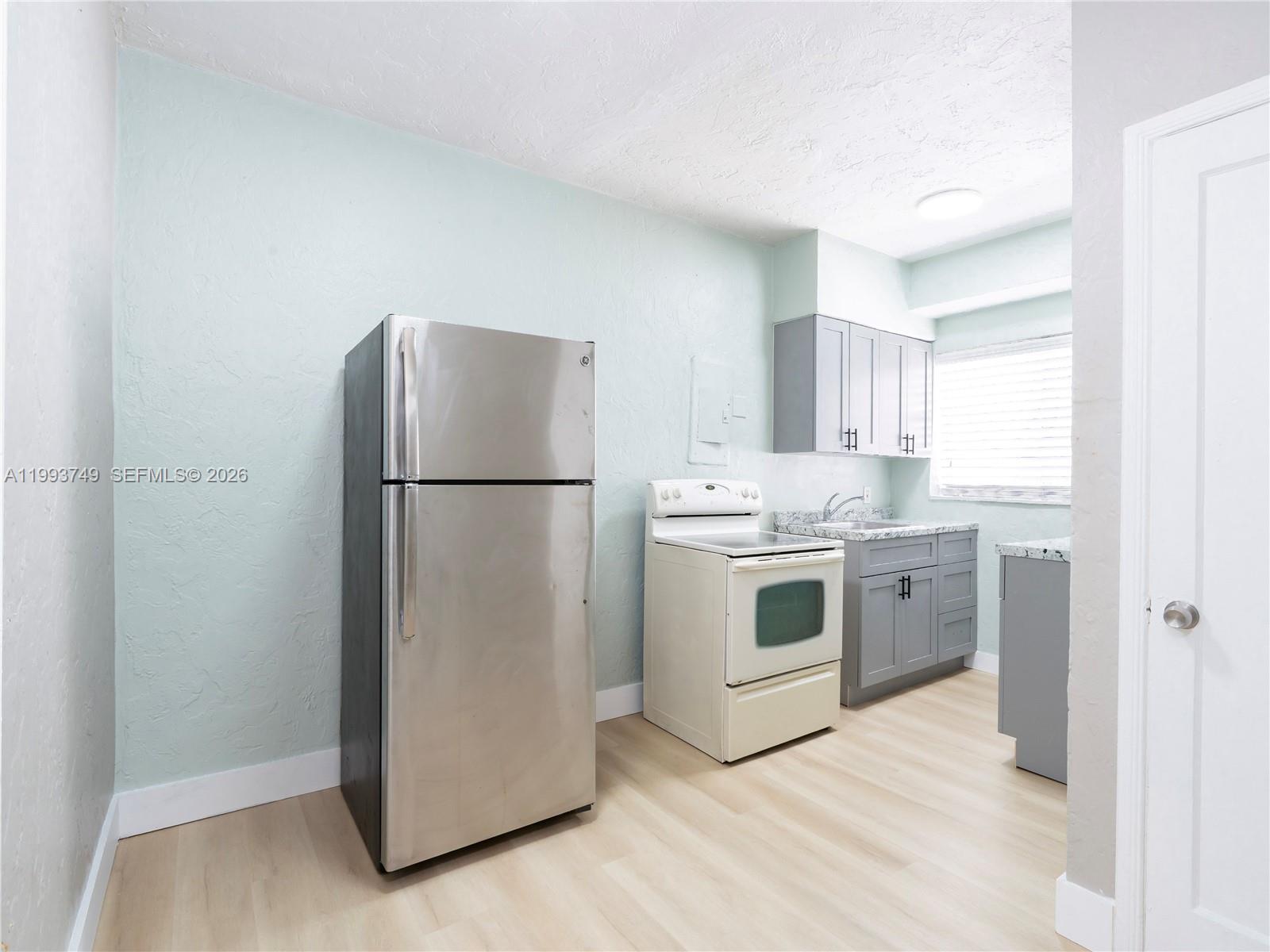 7635 Dickens Avenue, Unit 3 Miami Beach, FL 33141 - Photo 4 of 9 a kitchen with a refrigerator sink and cabinets
