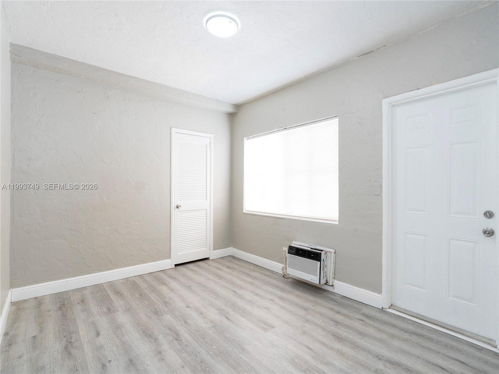7635 Dickens Avenue, Unit 3 Miami Beach, FL 33141 - Photo 7 of 9 a view of a livingroom with wooden floor and a window