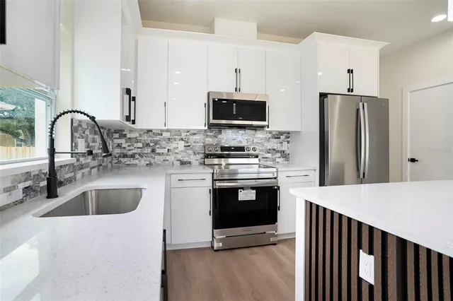 a kitchen with stainless steel appliances granite countertop a sink stove and refrigerator