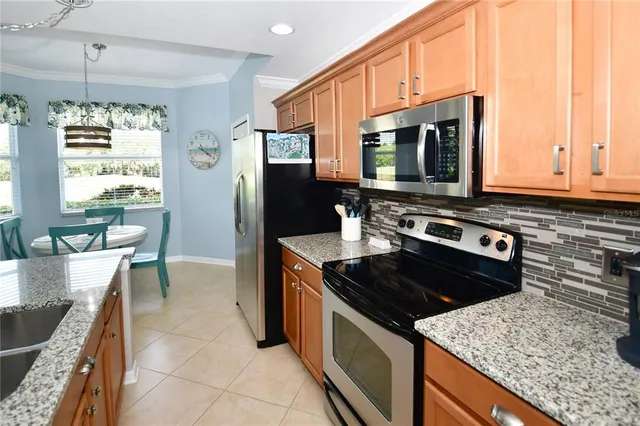 a kitchen with stainless steel appliances granite countertop a stove microwave and refrigerator