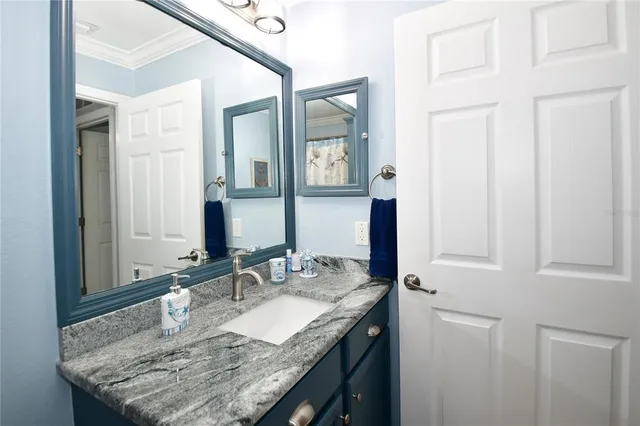 a bathroom with a granite countertop sink and a mirror