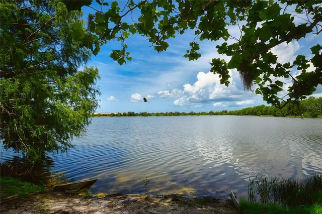 a view of an ocean with boats and trees in the background