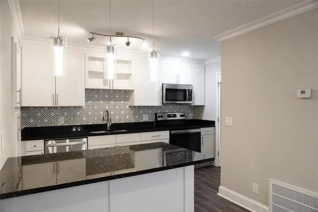 a kitchen with stainless steel appliances granite countertop a sink and a stove
