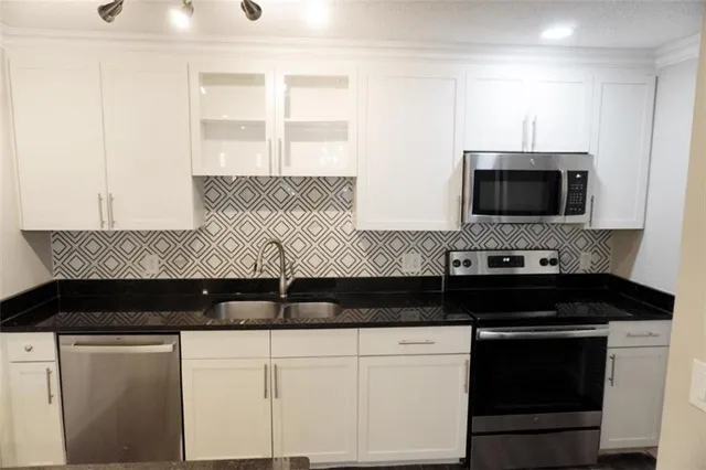 a close view of a stove a sink and dishwasher with kitchen island