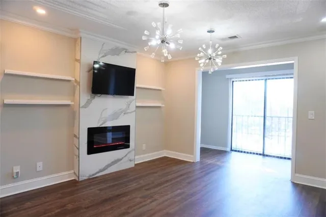 a view of a livingroom with a fireplace a chandelier and wooden floor