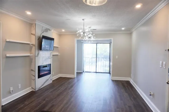 a view of a room with wooden floors and chandelier