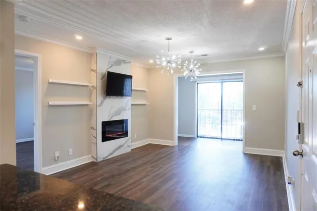 a view of a livingroom with a fireplace wooden floor and chandelier