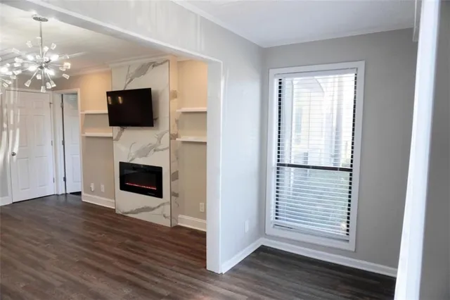 a view of a livingroom with a flat screen tv wooden floor and a fireplace