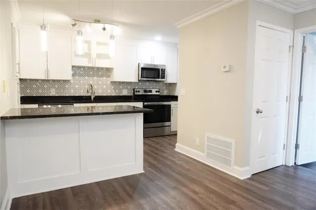 a kitchen with stainless steel appliances granite countertop a stove and a refrigerator