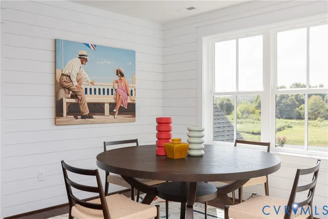 a view of a dining room with furniture a chandelier and wooden floor