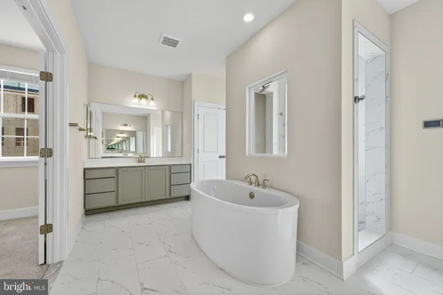 a bathroom with a bathtub sink and mirror