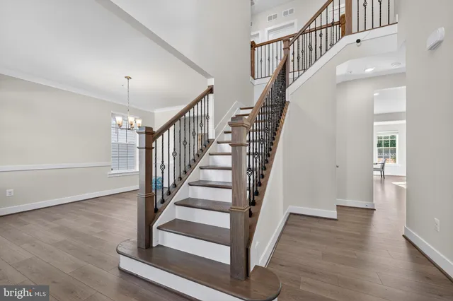 a view of staircase with wooden floor and a chandelier