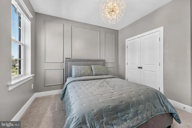 a bedroom with a large bed and a chandelier