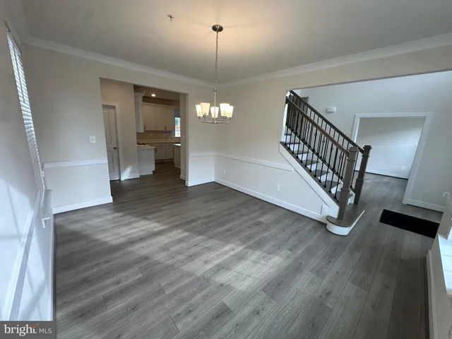 a view of a hallway with wooden floor and stairs