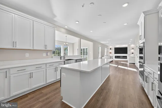 a kitchen with counter top space a sink wooden floor and stainless steel appliances