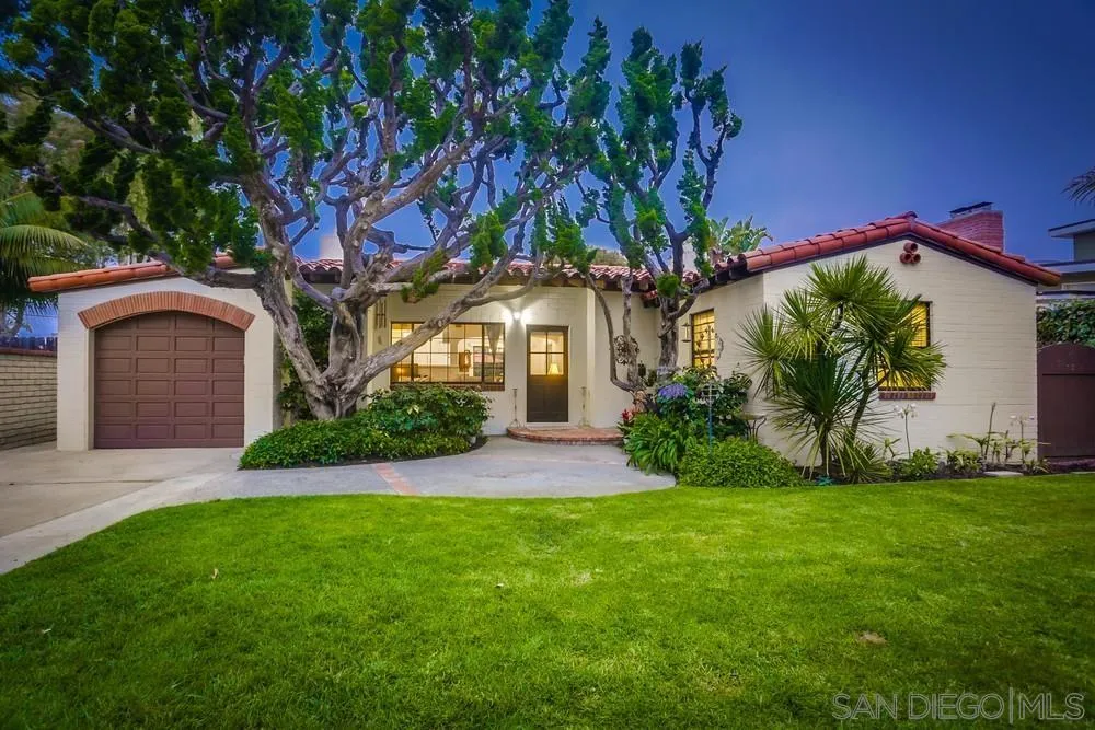 a front view of a house with a garden and plants