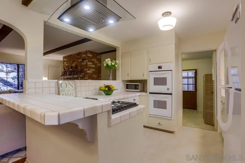 506 Pacific Avenue Solana Beach, CA 92075 - Photo 5 of 13 a kitchen with stainless steel appliances kitchen island granite countertop a stove and a sink