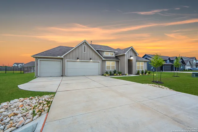a view of a white house with a big yard and large trees