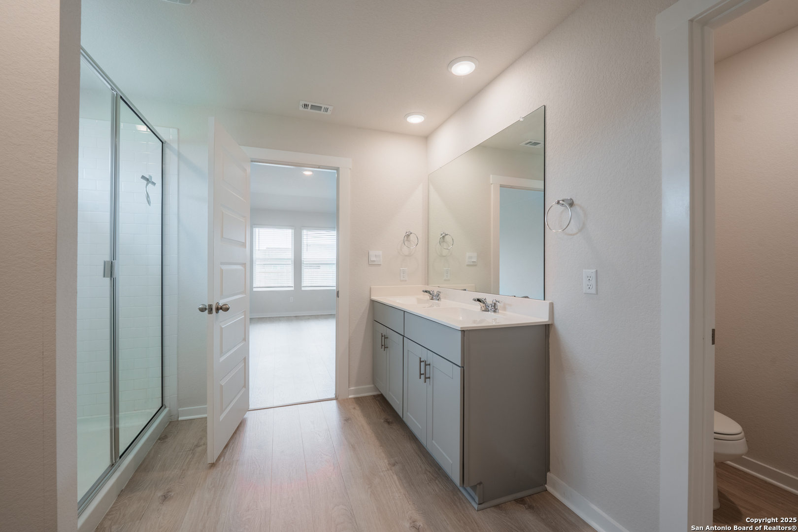 125 Nicks Cove Lockhart, TX 78644 - Photo 22 of 40 a bathroom with a double vanity sink and mirror with shower