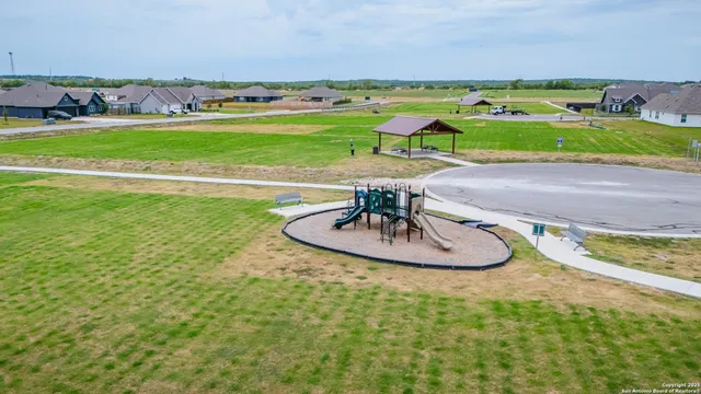 an aerial view of a pool an outdoor space and seating area