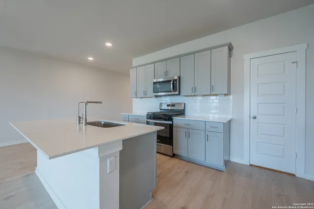 a kitchen with a sink a stove a refrigerator and cabinets