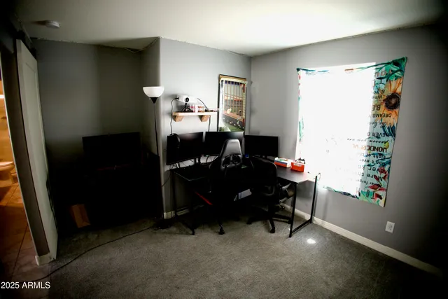 a view of a workspace with furniture and a window