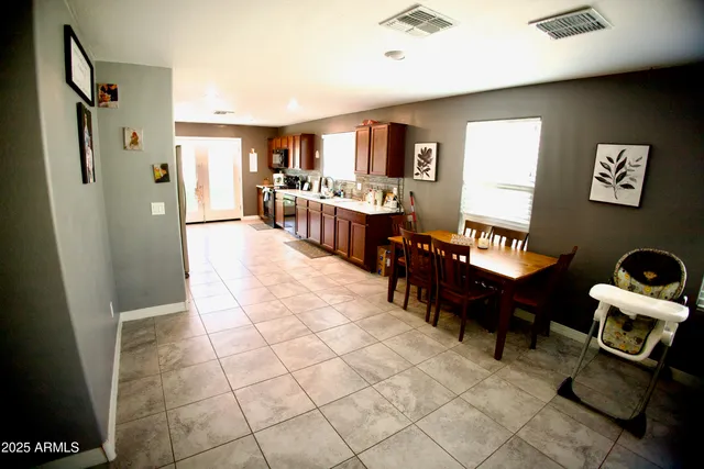 a living room with couches and kitchen view with wooden floor