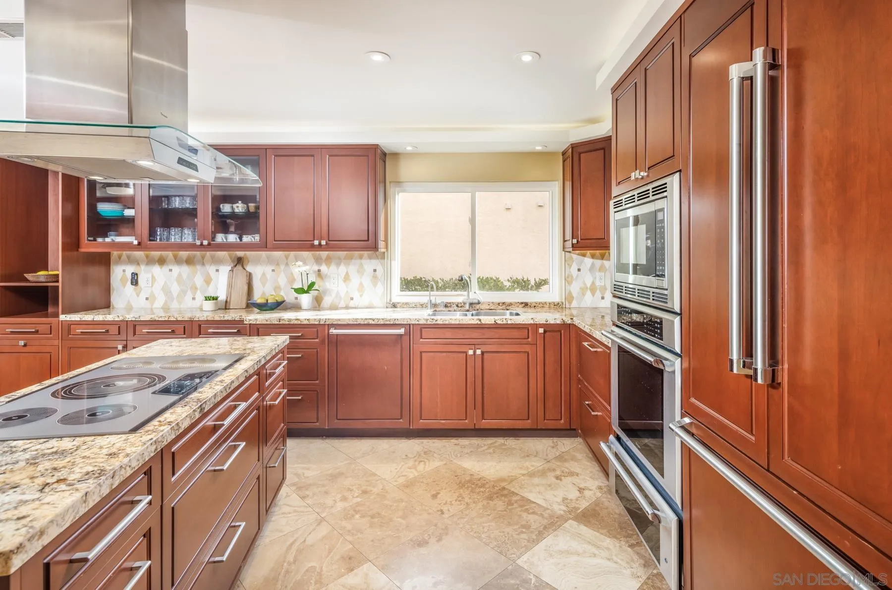 89 Trinidad Bend Coronado, CA 92118 - Photo 11 of 40 a kitchen with stainless steel appliances granite countertop a refrigerator a sink and wooden cabinets