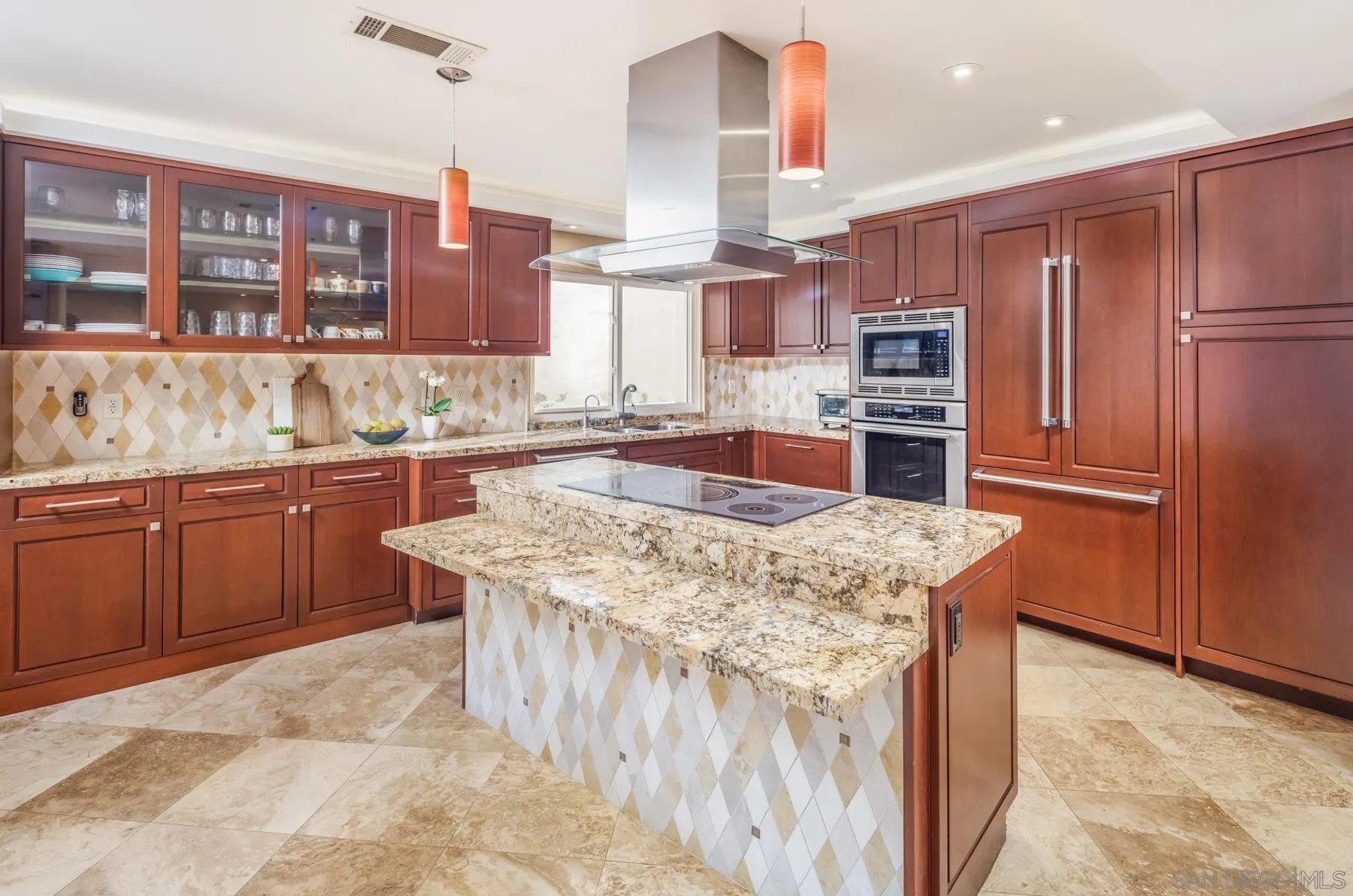 89 Trinidad Bend Coronado, CA 92118 - Photo 12 of 40 a kitchen with stainless steel appliances kitchen island granite countertop a table chairs sink and cabinets