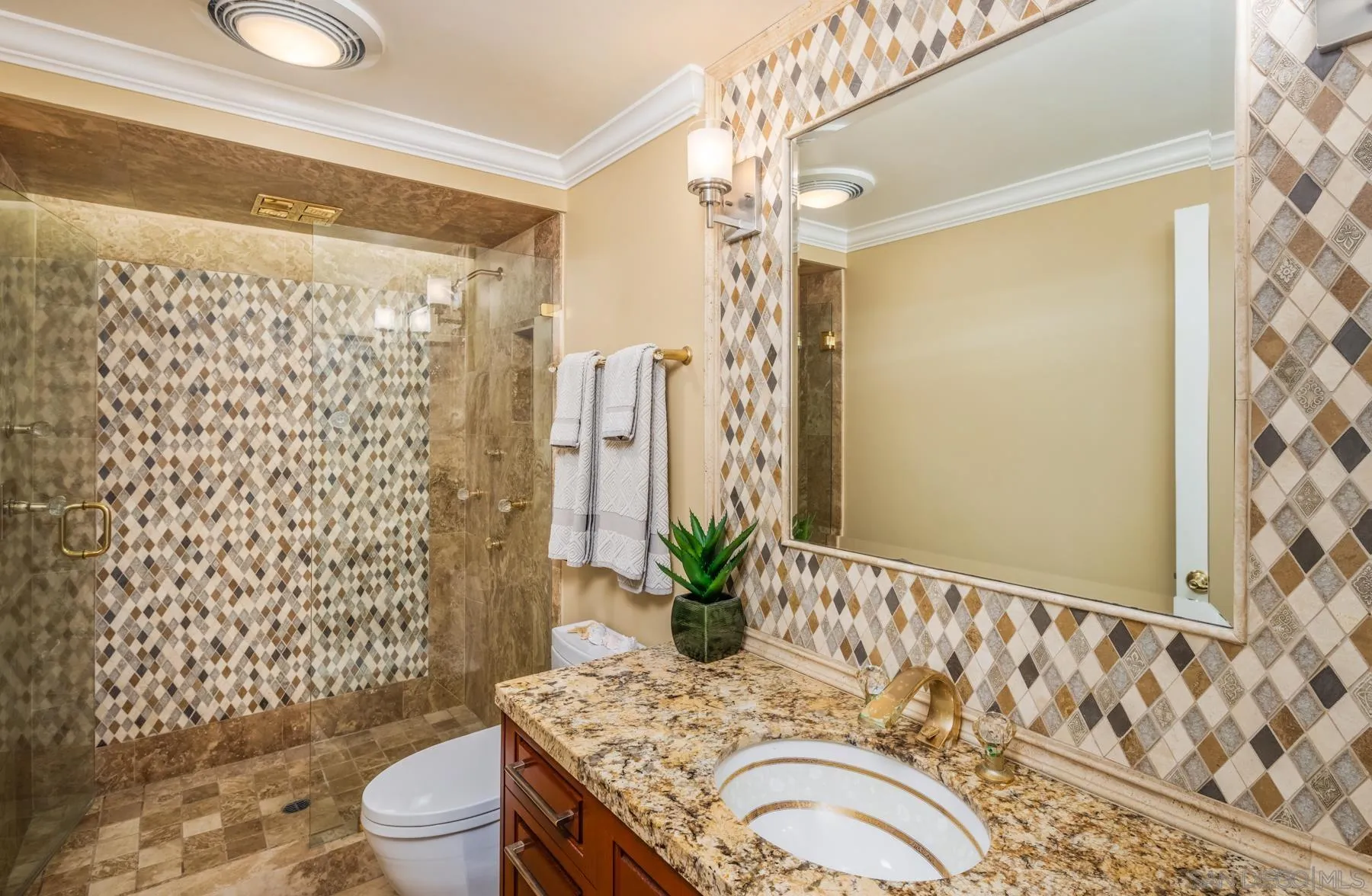 89 Trinidad Bend Coronado, CA 92118 - Photo 26 of 40 a bathroom with a granite countertop sink a toilet and shower curtain