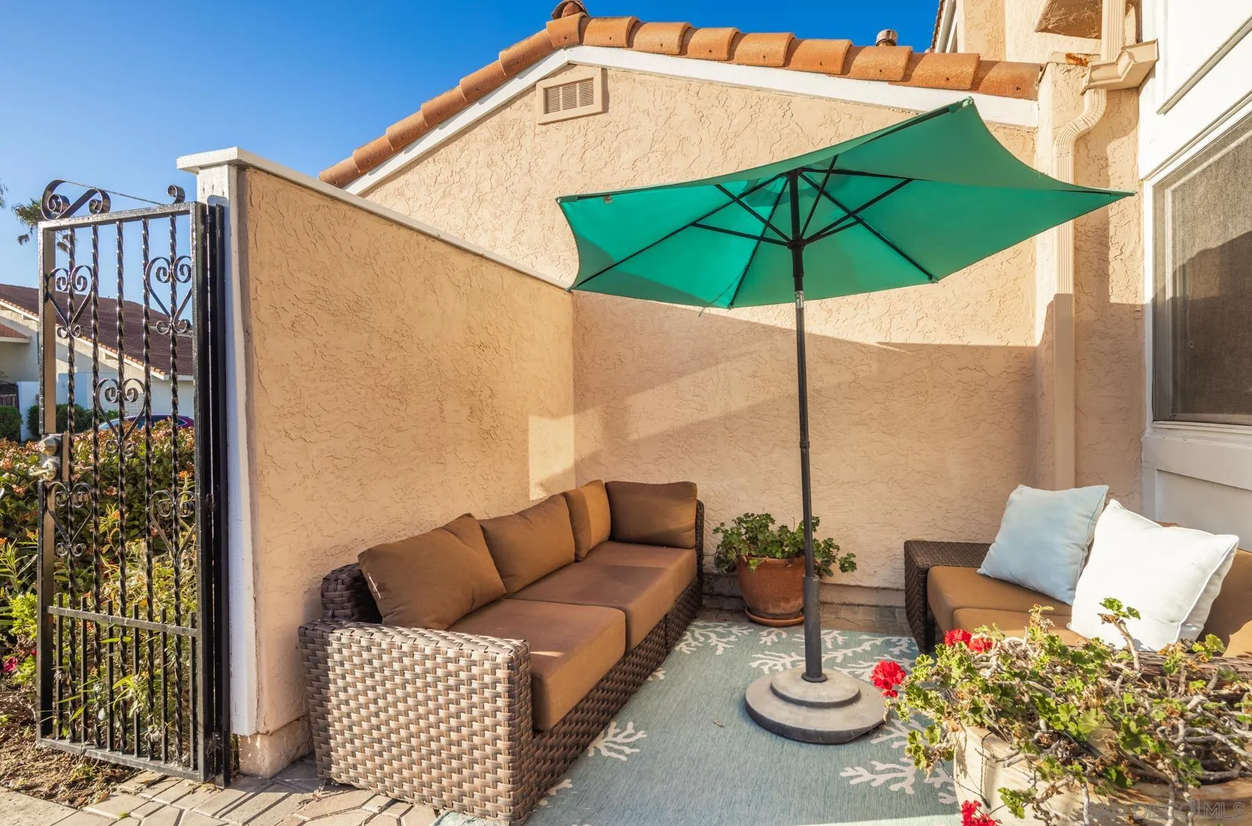 89 Trinidad Bend Coronado, CA 92118 - Photo 27 of 40 a backyard of a house with table and chairs under an umbrella
