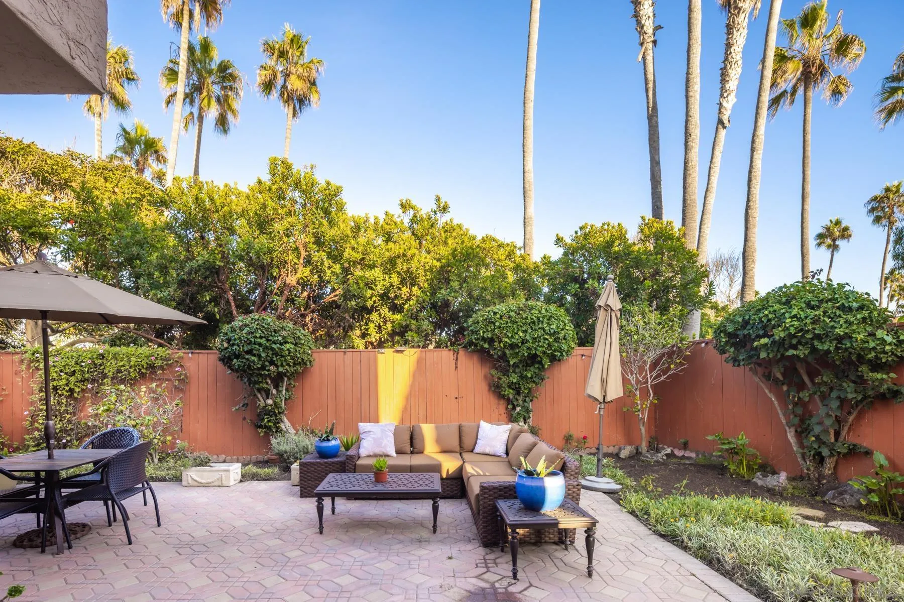 89 Trinidad Bend Coronado, CA 92118 - Photo 29 of 40 a backyard of a house with table and chairs under an umbrella