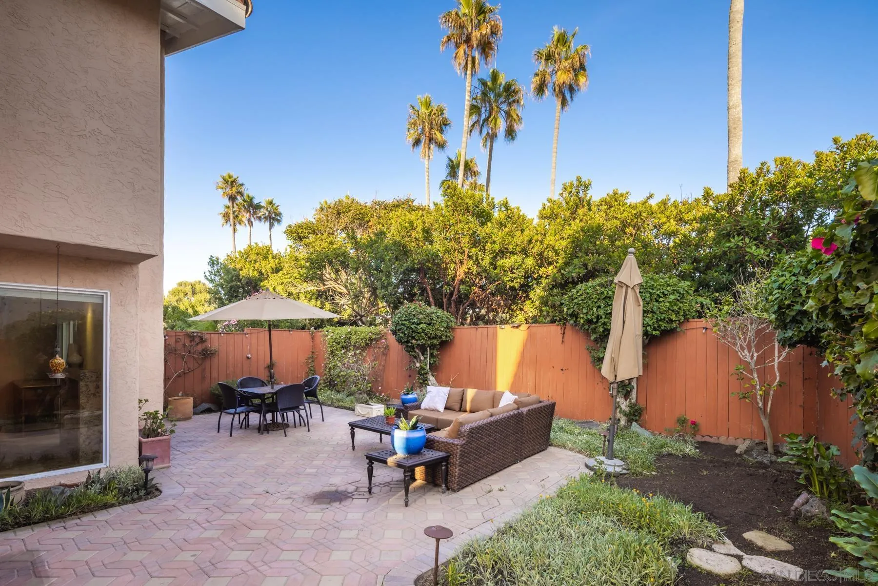 89 Trinidad Bend Coronado, CA 92118 - Photo 34 of 40 a view of a backyard with a table and chairs under an umbrella