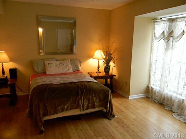 11006 Running Ridge Road, Unit 8441 Charlotte, NC 28226 - Photo 11 of 12 a bedroom with a bed and a mirror
