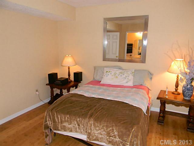 11006 Running Ridge Road, Unit 8441 Charlotte, NC 28226 - Photo 12 of 12 a bedroom with a bed and a mirror