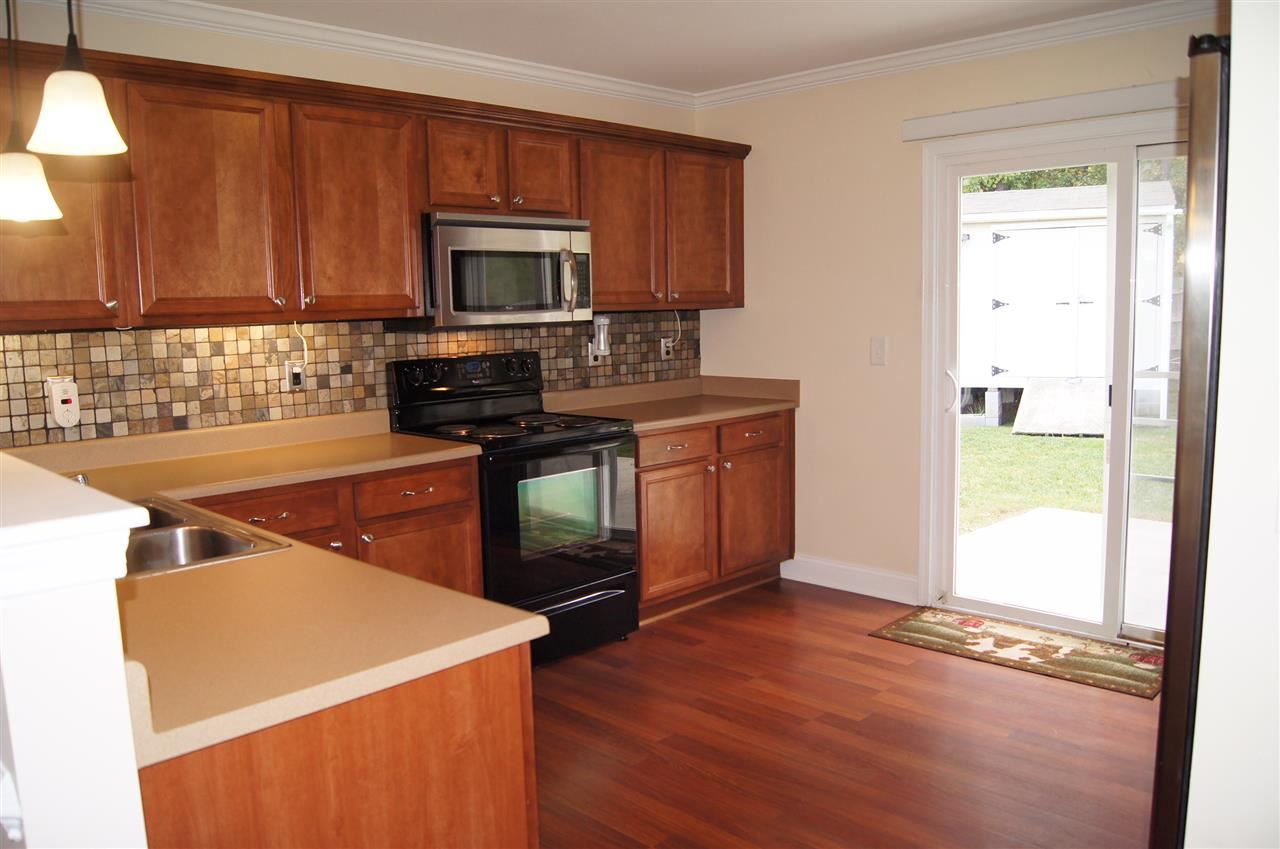 3029 Varcroft Road Knightdale, NC 27545 - Photo 13 of 25 a kitchen with stainless steel appliances a stove a microwave a sink and cabinets