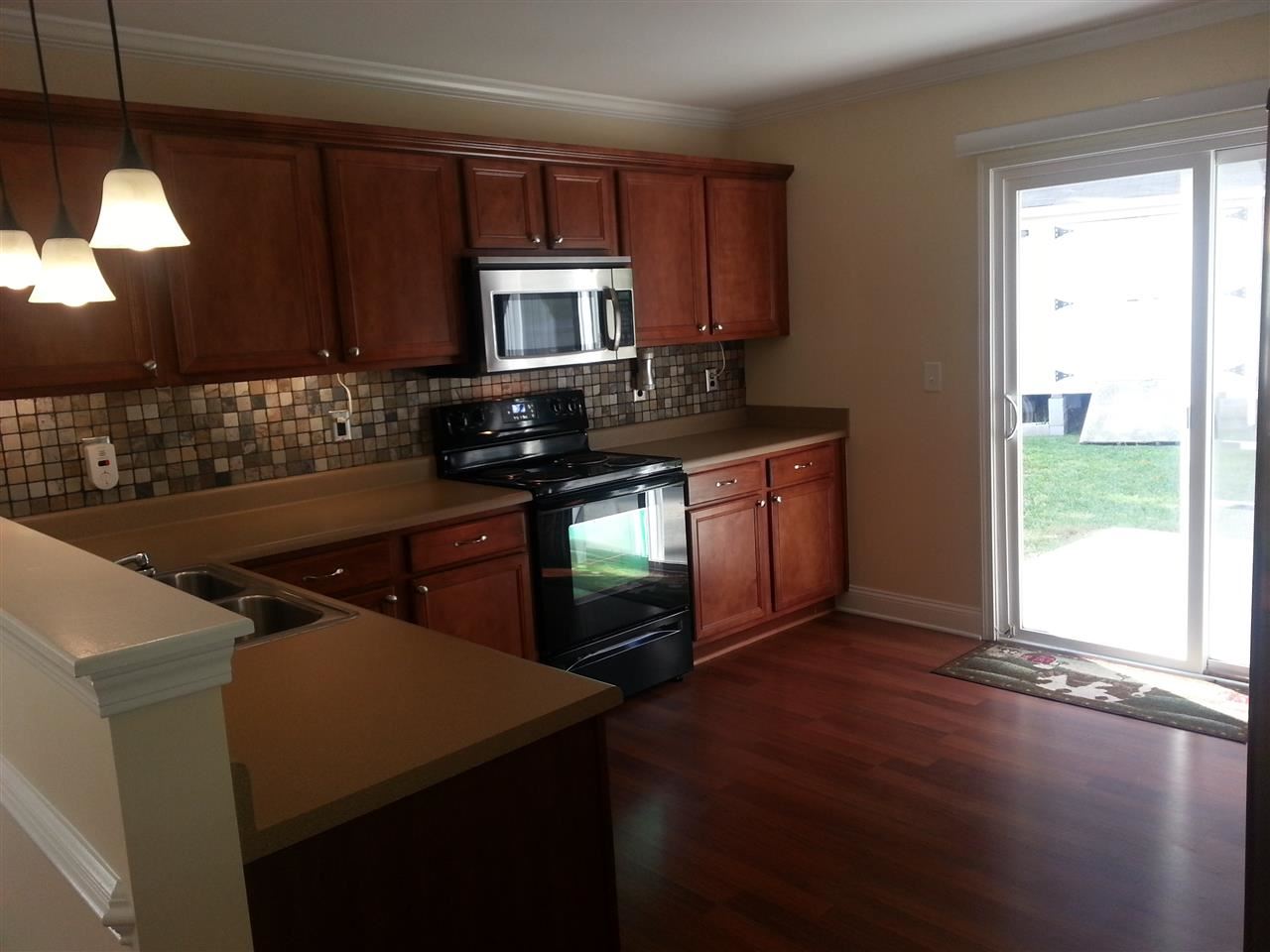 3029 Varcroft Road Knightdale, NC 27545 - Photo 9 of 25 a kitchen with stainless steel appliances granite countertop a stove a sink and a microwave