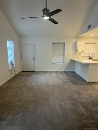 a view of an empty room with window and cabinet