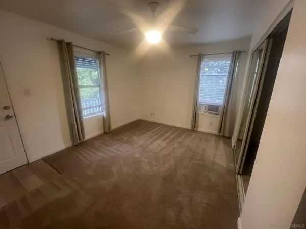 an empty room with windows and closet
