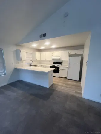 a view of a kitchen with a sink stove cabinets and a window