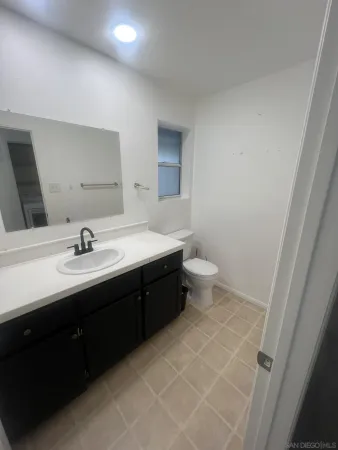 a bathroom with a double vanity sink toilet and a mirror