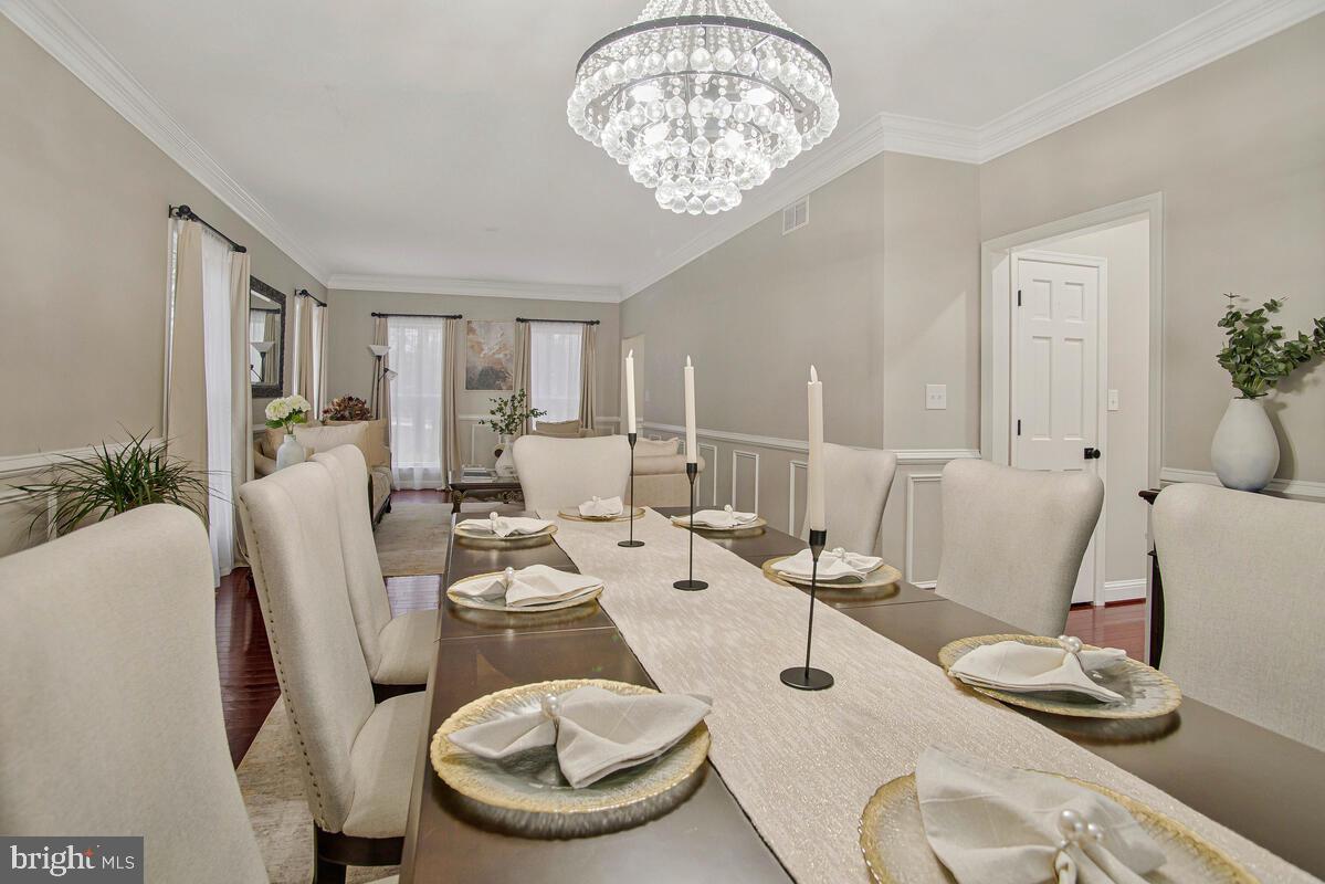 8241 Surratts Road Clinton, MD 20735 - Photo 11 of 55 a dining room with furniture a chandelier and wooden floor