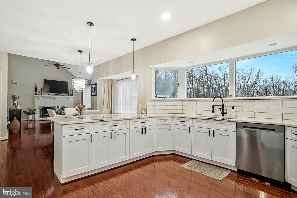 8241 Surratts Road Clinton, MD 20735 - Photo 12 of 55 a kitchen with sink stove and white cabinets with wooden floor
