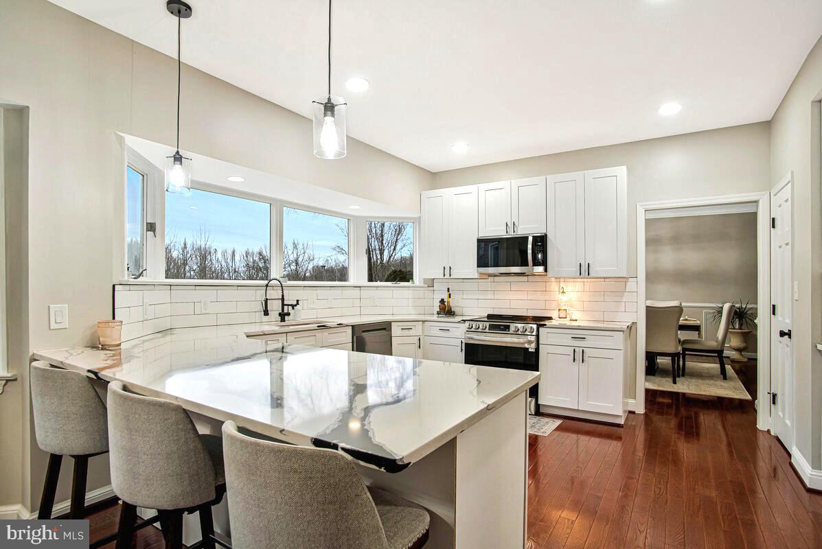 8241 Surratts Road Clinton, MD 20735 - Photo 13 of 55 a kitchen with stainless steel appliances granite countertop a sink a stove and a refrigerator