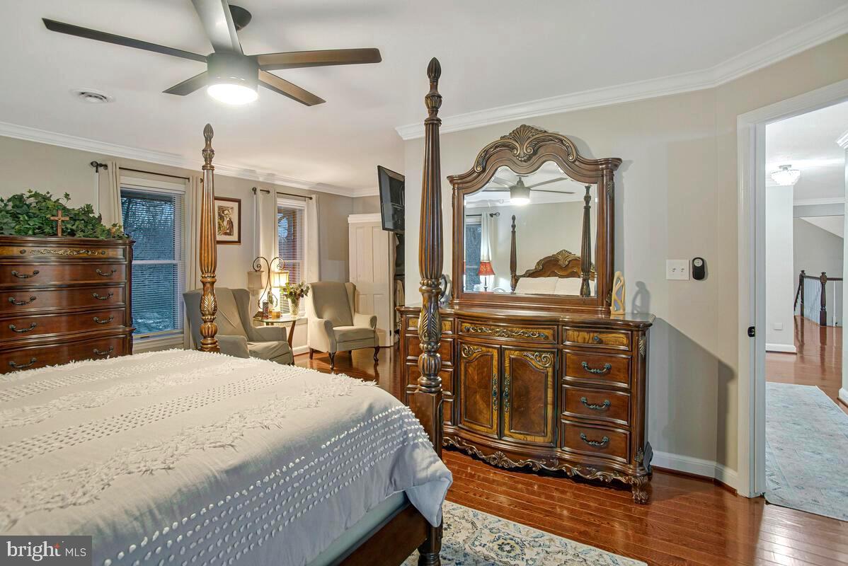 8241 Surratts Road Clinton, MD 20735 - Photo 34 of 55 a bedroom with a bed a dresser and wooden floor